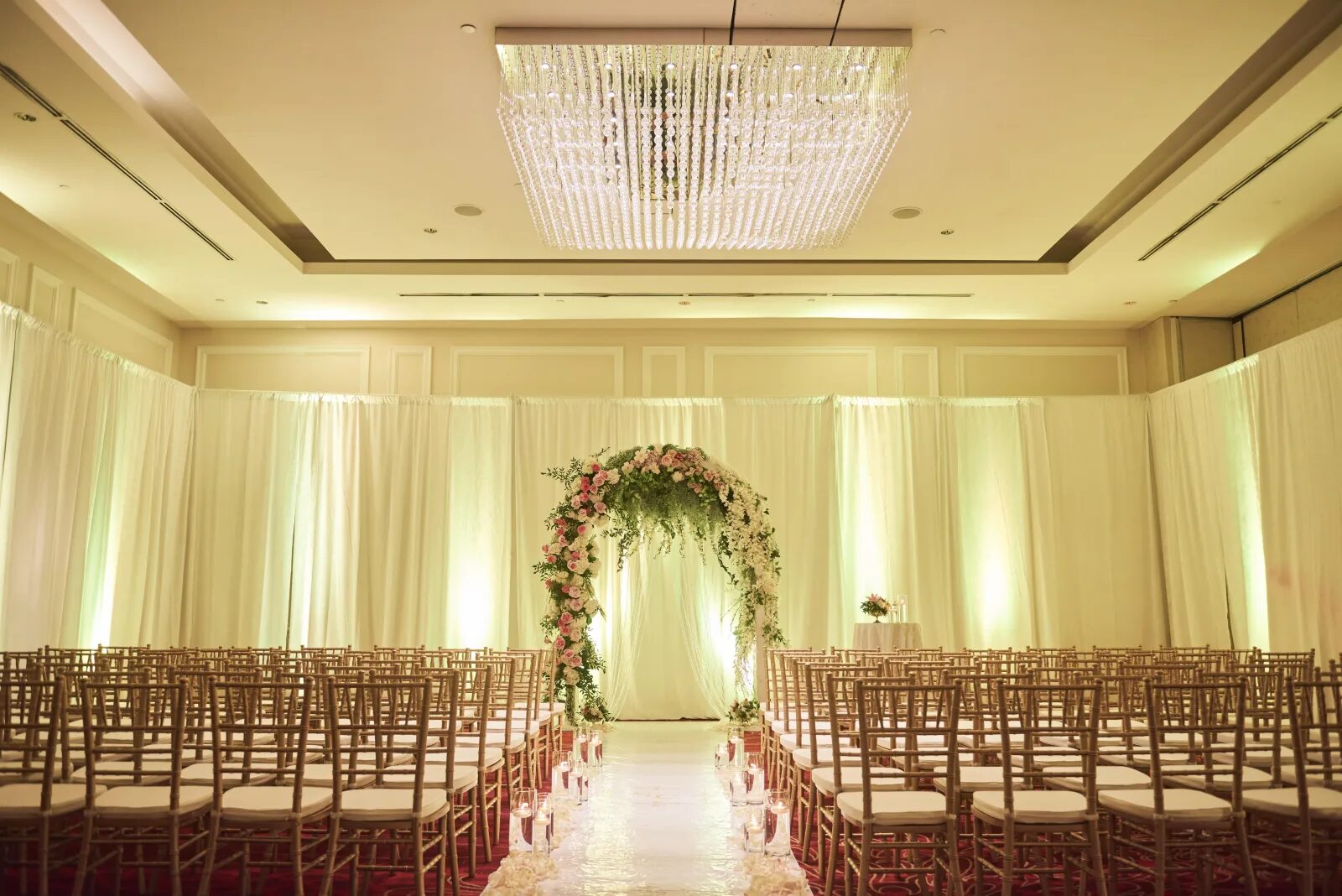 Wedding ceremony with a floral arch in the Harbourfront Ballroom